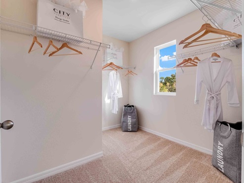 Spacious walk in closet with abundant shelving and storage.