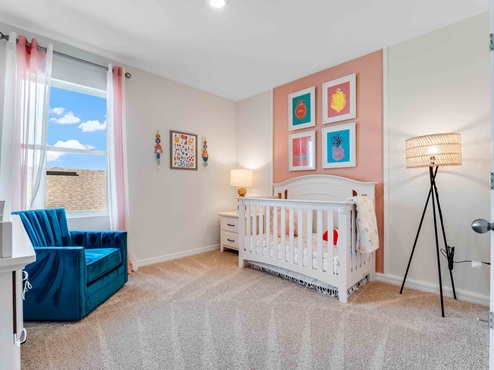 Child's nursery with crib, closet, soft seating and storage.