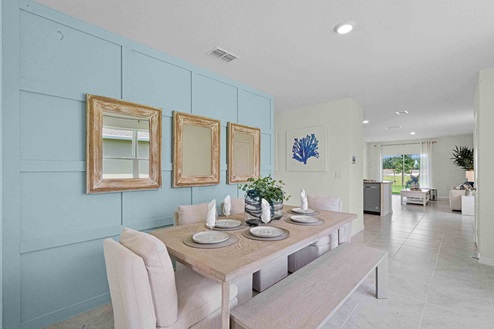 Dining room adjacent to the kitchen with table, chairs and tile flooring.