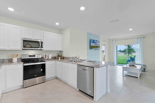 Kitchen with island seating, granite counters, spacious pantry and stainless-steel appliances.