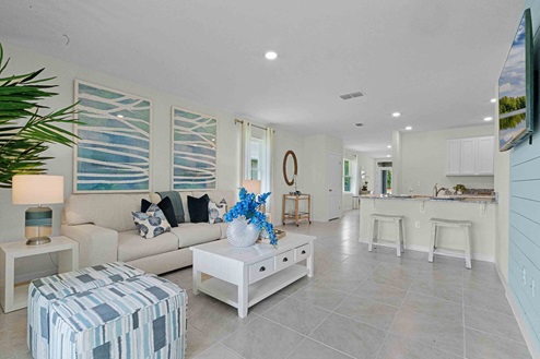 Open concept living area with couch seating overseeing kitchen.