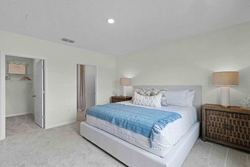 Spare bedroom for guests, with bed, dresser, and ample closet storage.