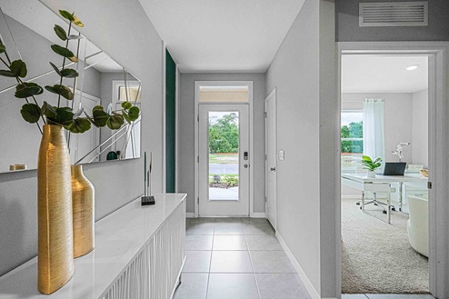 Home entry way thru the front door with tile flooring and a view to the living space.