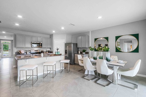 Kitchen with island seating, granite counters, spacious pantry and stainless-steel appliances.
