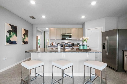 Kitchen with tall cabinetry, appliances, walk in pantry and tile flooring.