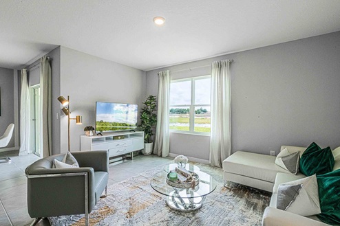 Open concept living area with couch seating and access to the backyard thru slider door.