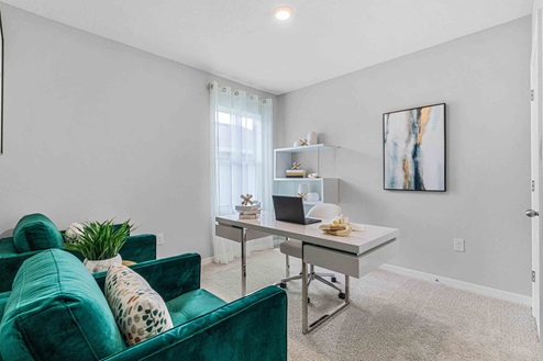 Multi purpose office space with desk, seating and windows for natural lighting.
