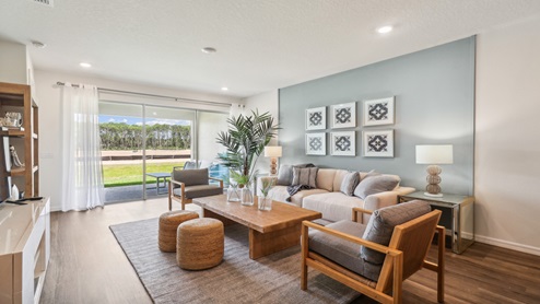 Open concept living area with couch seating and access to the backyard thru slider door.
