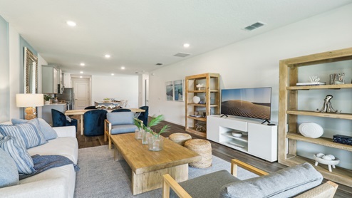 Open concept living area with couch seating overseeing kitchen.
