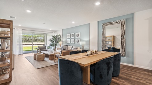 Open concept living area with couch seating overseeing kitchen.