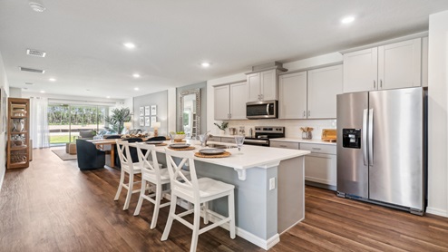Kitchen with island seating, granite counters, spacious pantry and stainless-steel appliances.