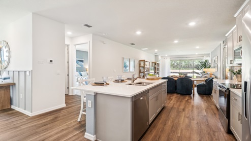 Kitchen with tall cabinetry, appliances, walk in pantry and tile flooring.