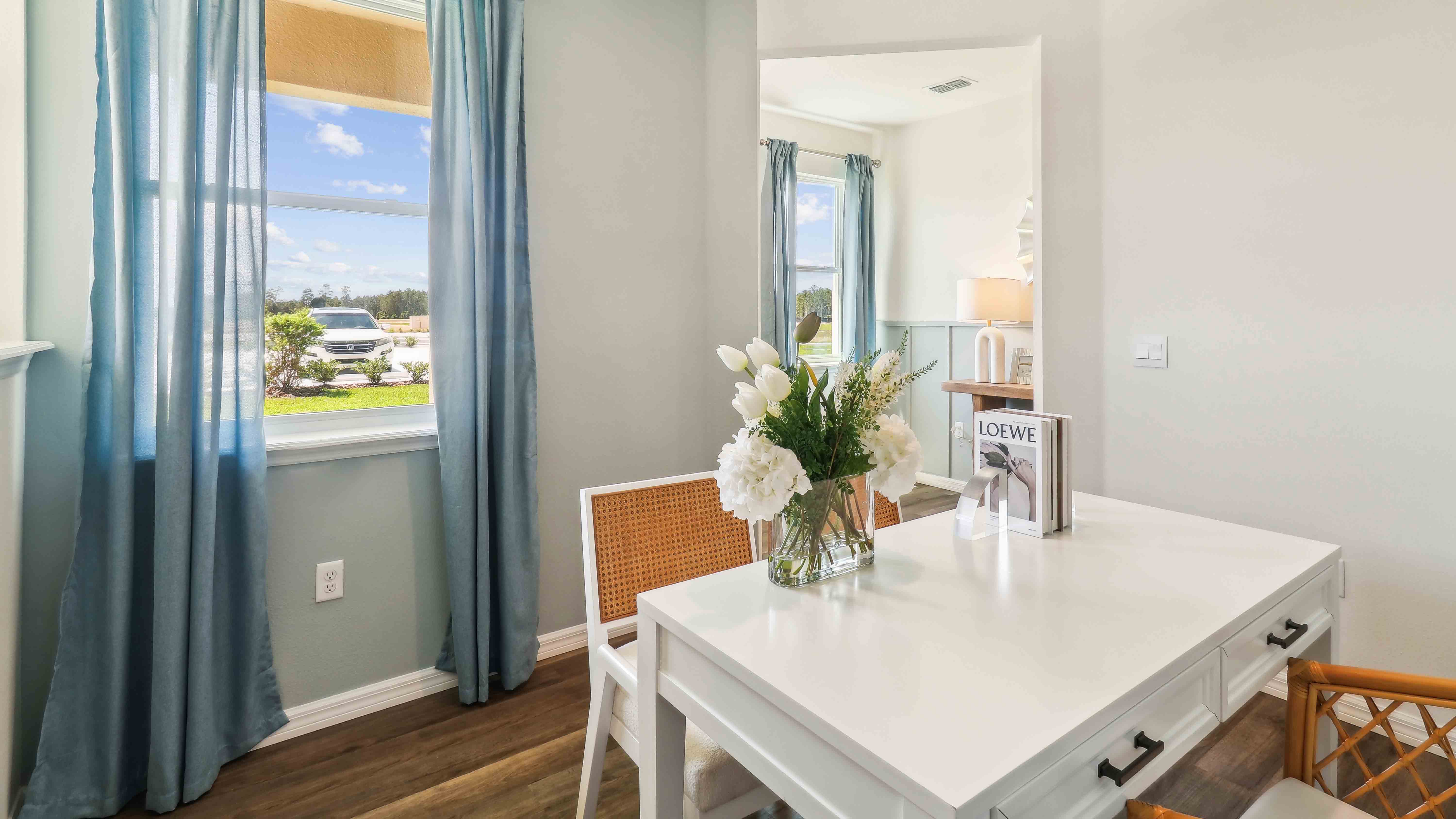 Spacious primary bedroom with king size bed, carpet flooring, natural lighting.