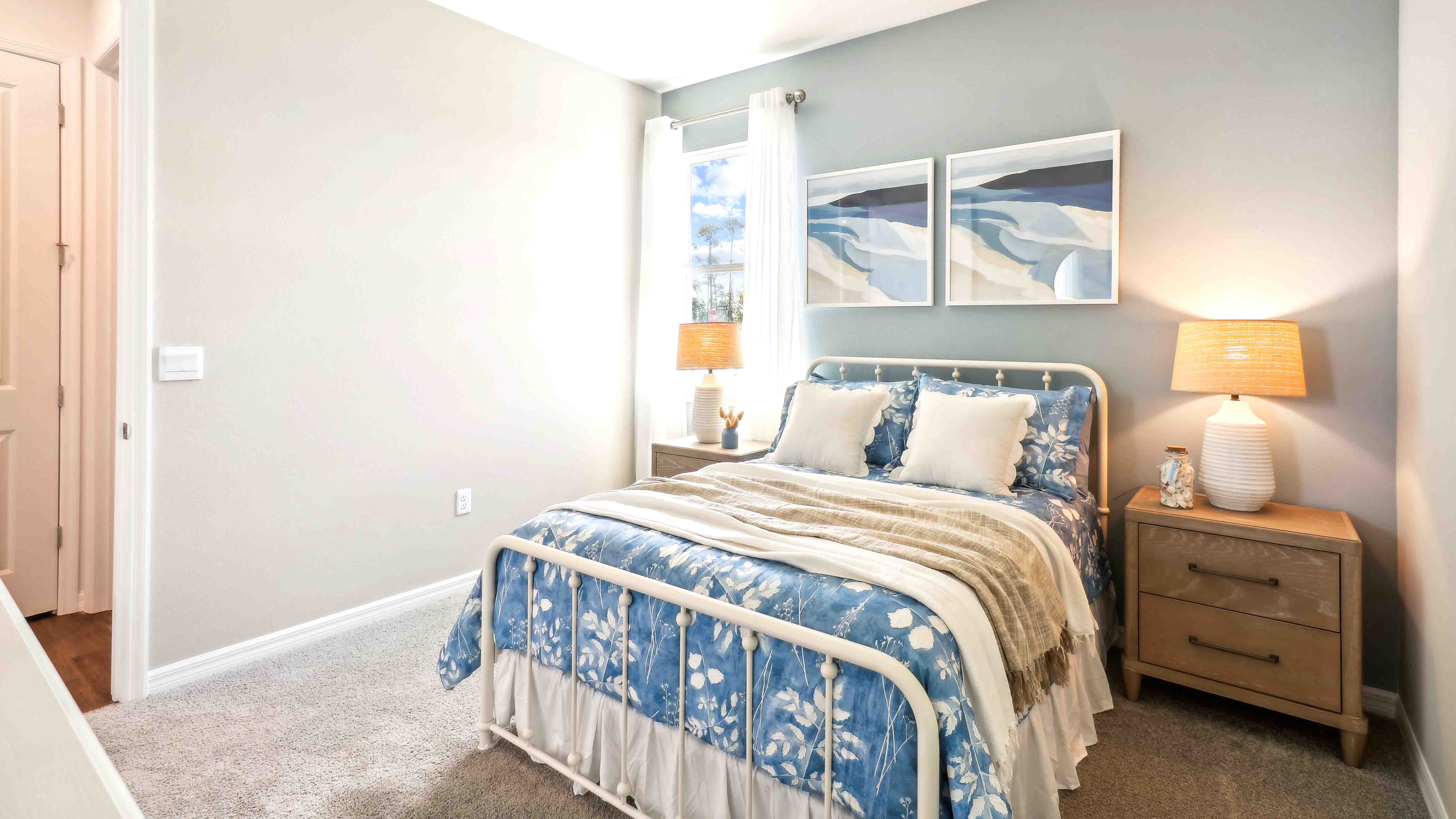 Spacious primary bedroom with king size bed, carpet flooring, natural lighting.