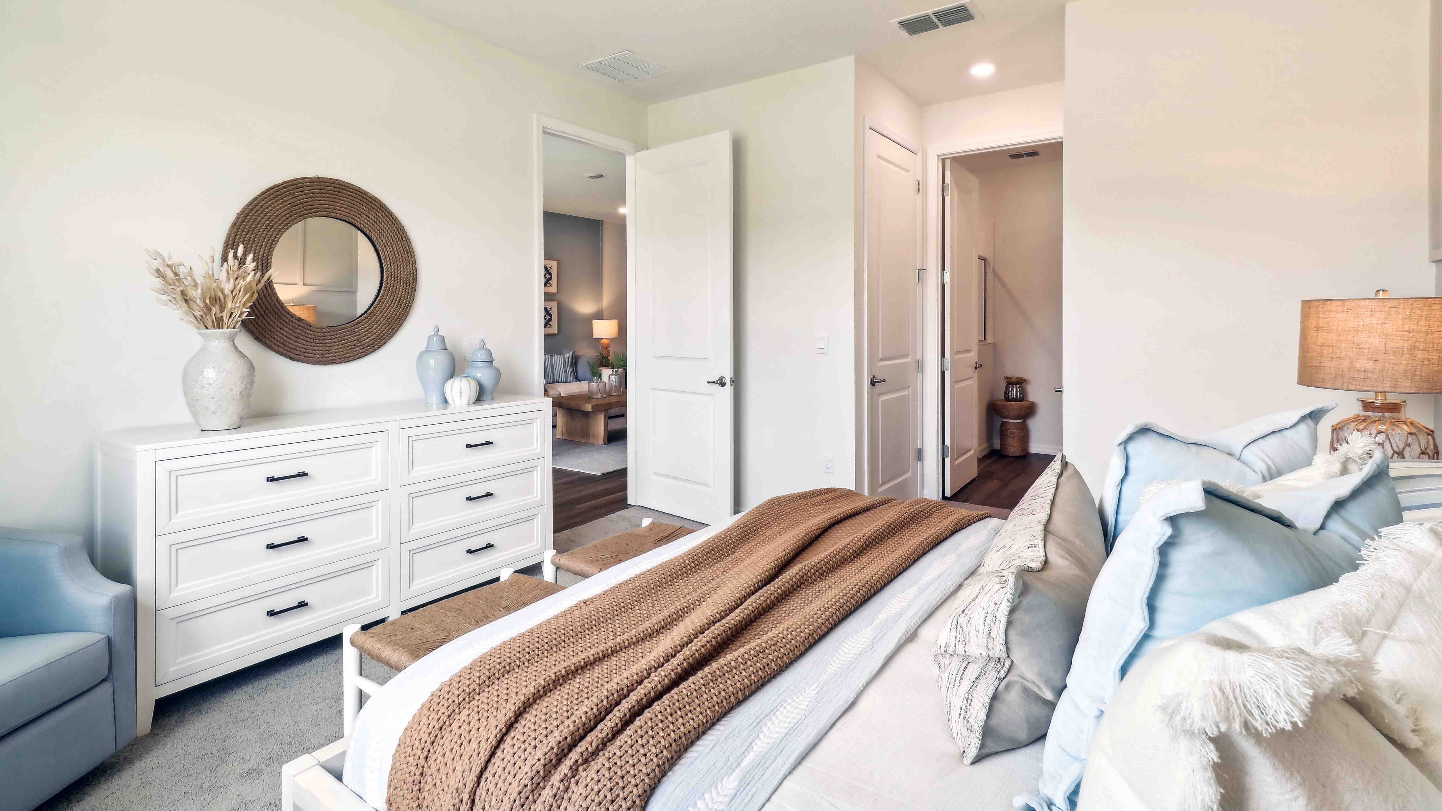 Spacious primary bedroom with king size bed, carpet flooring, natural lighting.