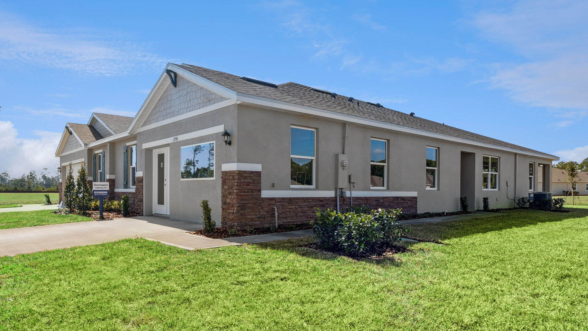 Single story new home with large windows and 2 car garage.