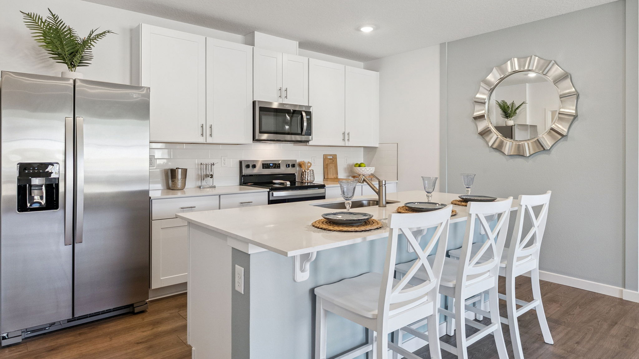 Kitchen with island seating, granite counters, spacious pantry and stainless-steel appliances.