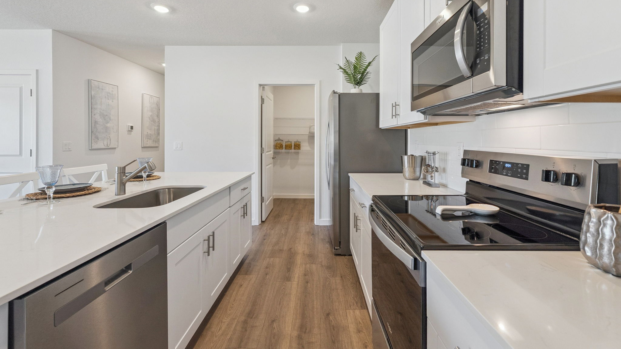 Kitchen with island seating, granite counters, spacious pantry and stainless-steel appliances.