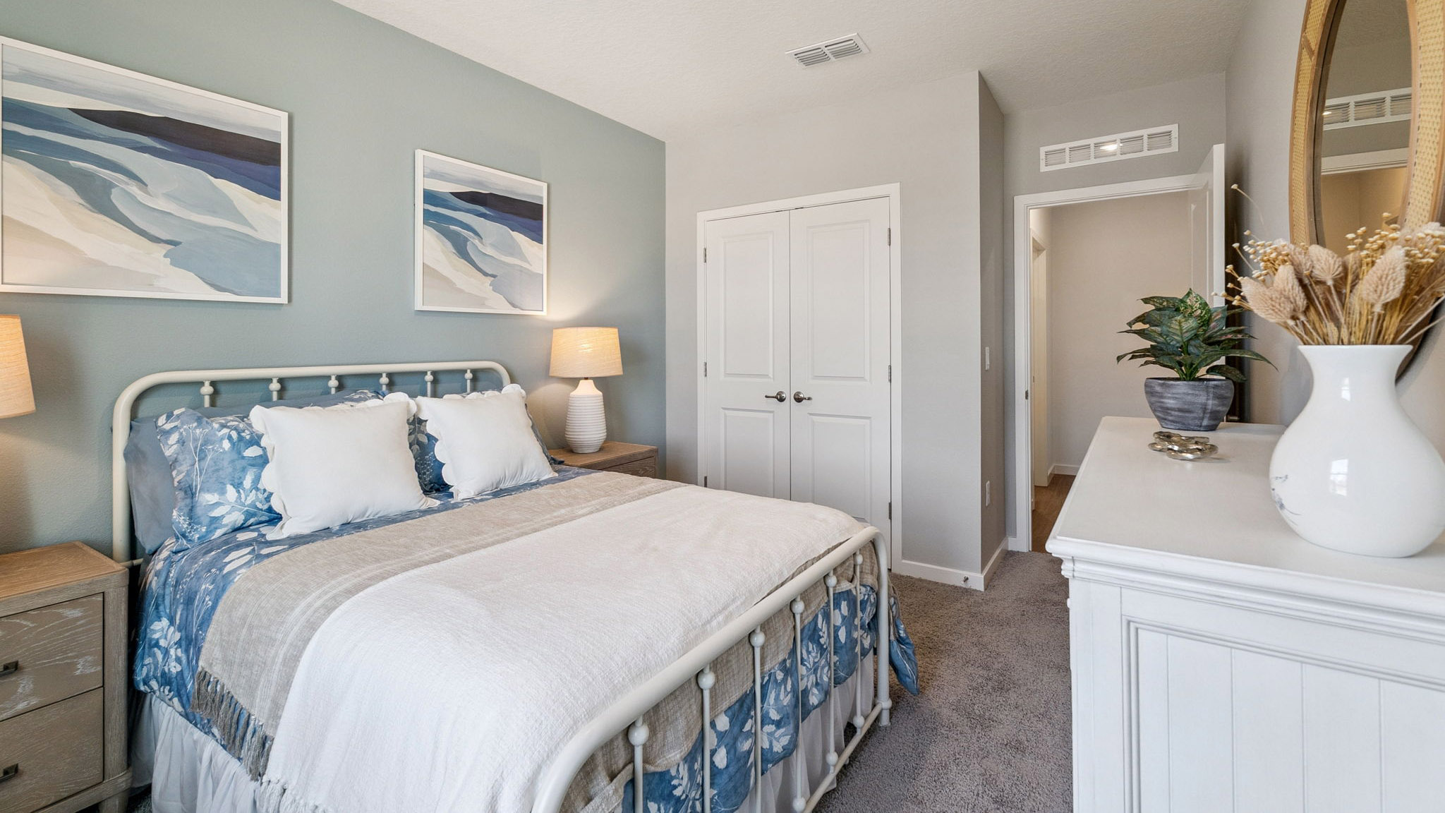 Spacious primary bedroom with king size bed, carpet flooring, natural lighting.