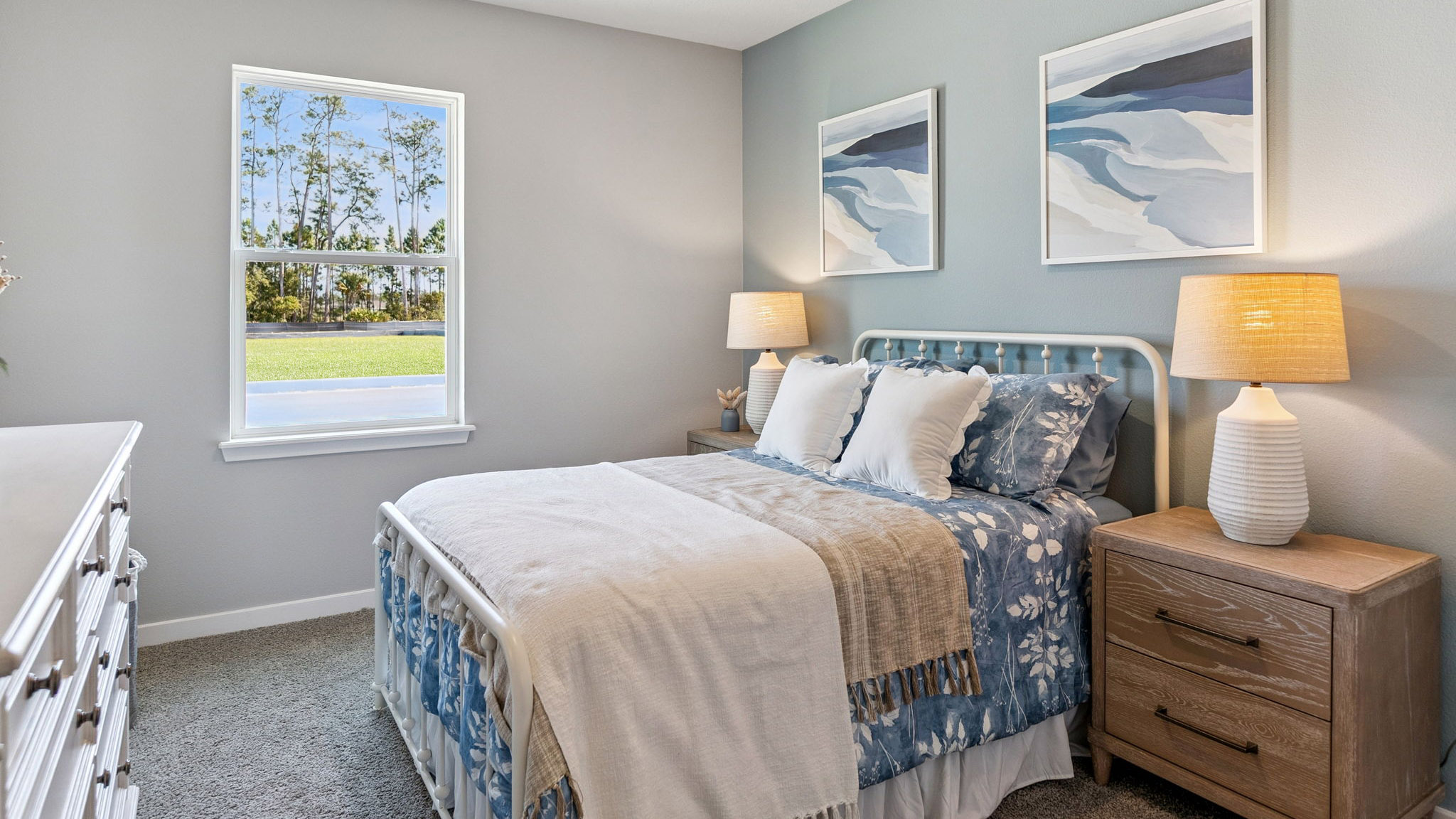 Spacious primary bedroom with king size bed, carpet flooring, natural lighting.