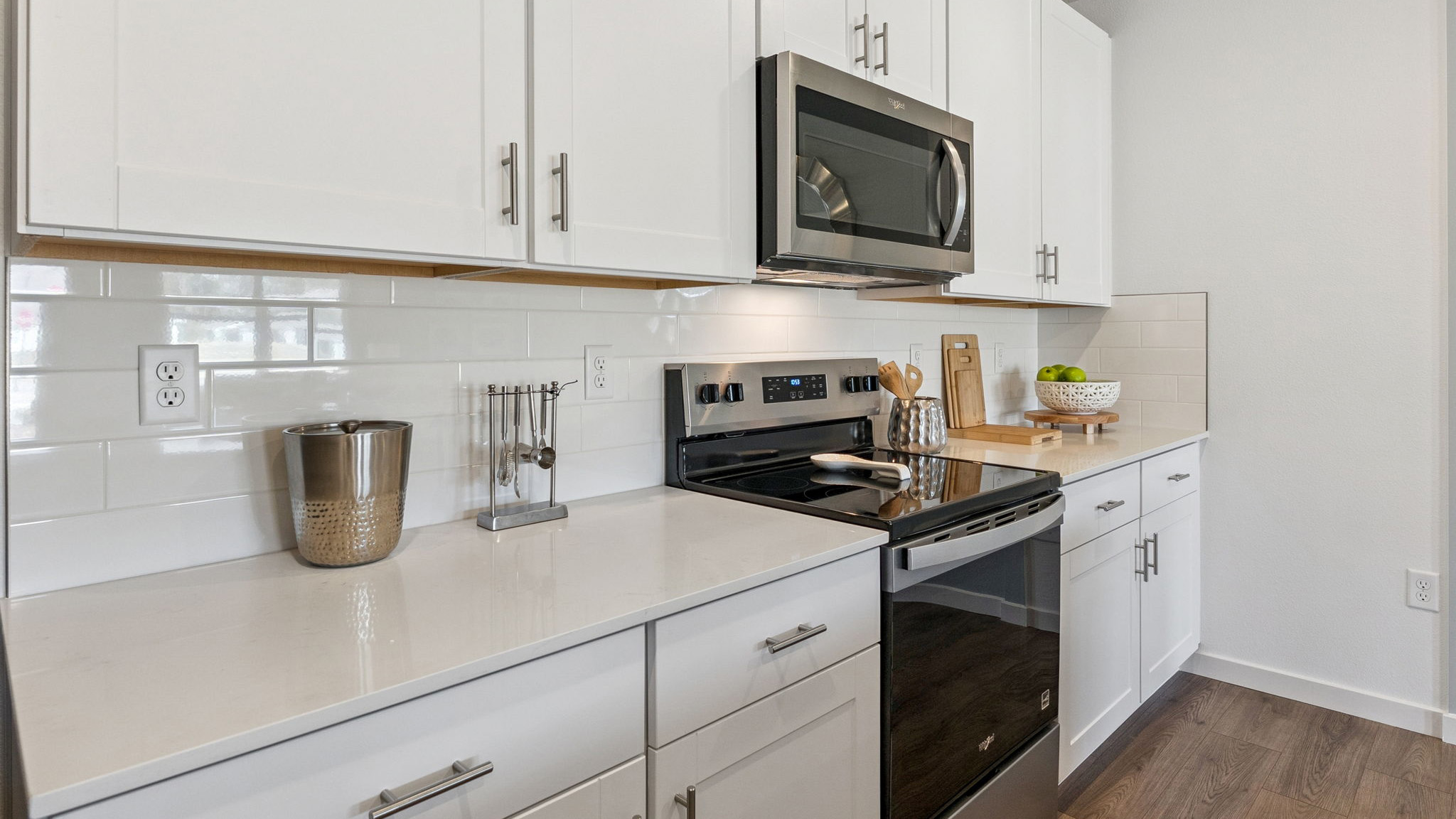 Kitchen with island seating, quartz counters, spacious pantry and stainless steel appliances.