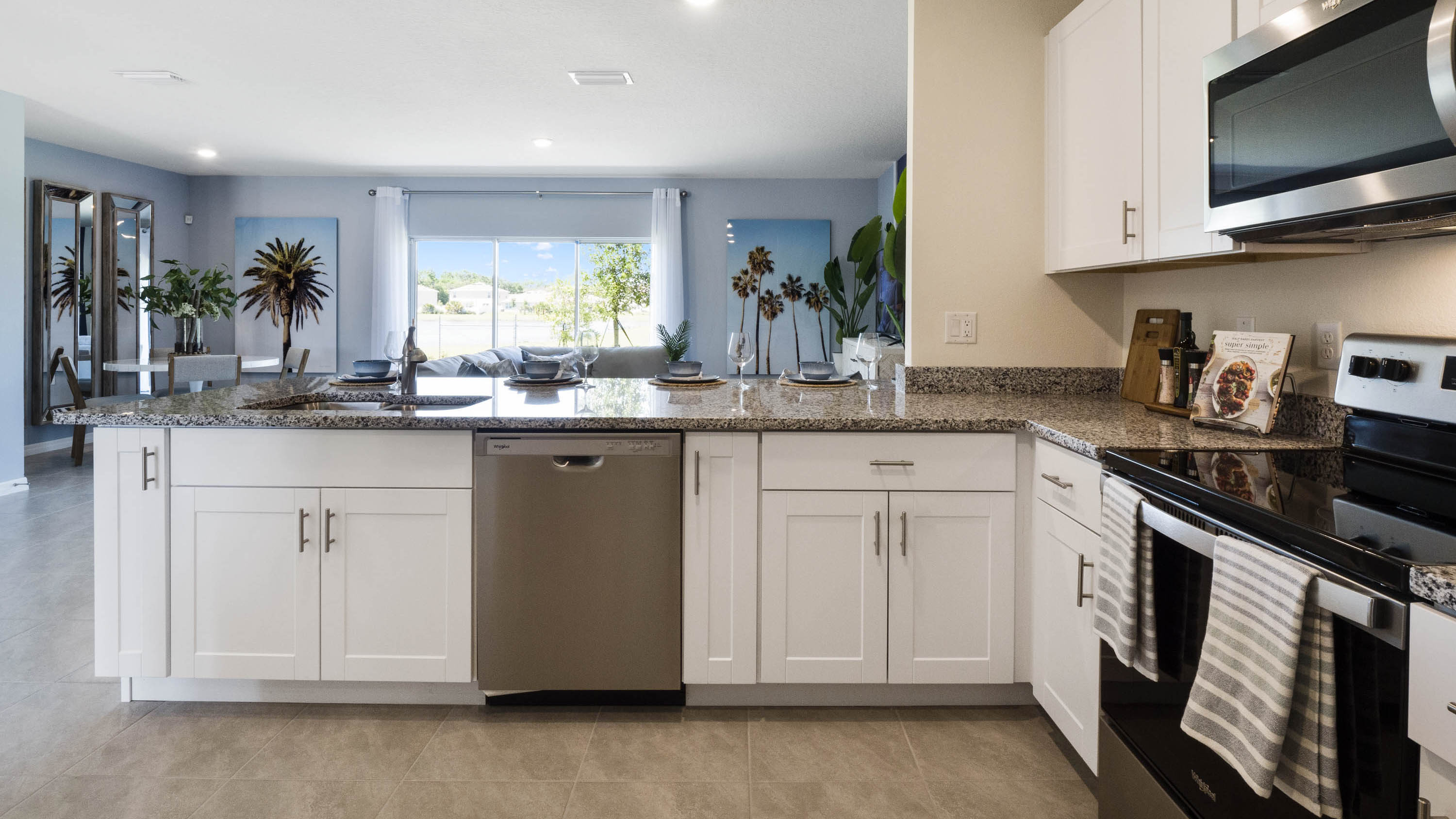 Kitchen with island seating, quartz counters, spacious pantry and stainless steel appliances.