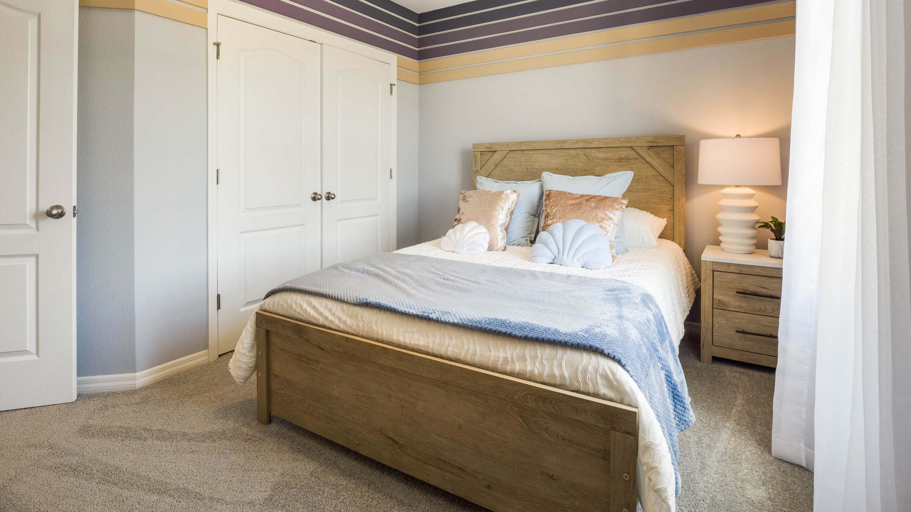 Guest bedroom with bed, nighstands and natural lighting.