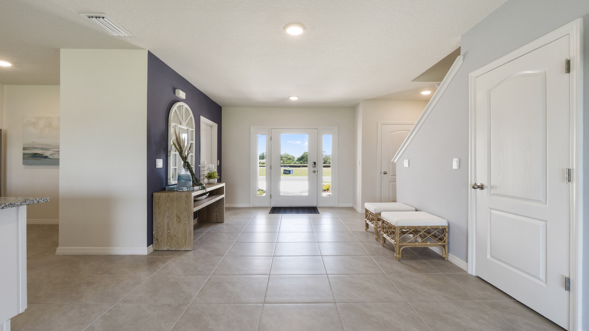 Home entry way thru the front door with tile flooring and a view to the living space.