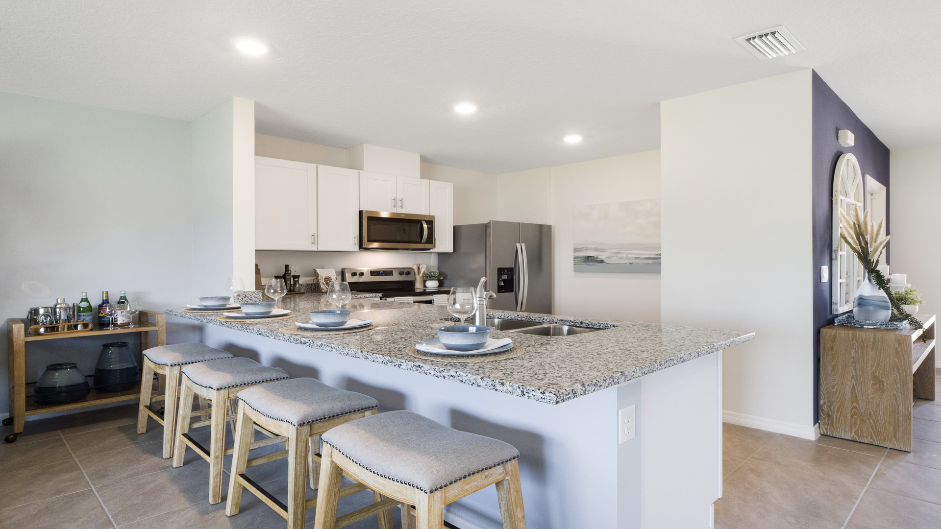 Kitchen with island seating, granite counters, spacious pantry and stainless-steel appliances.