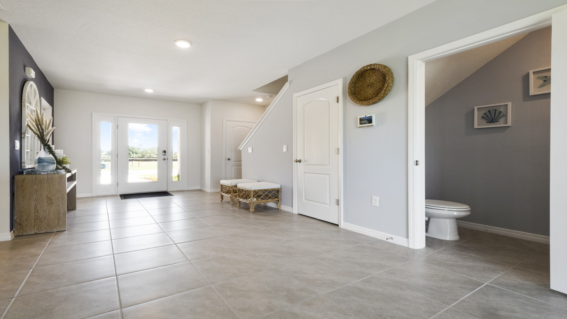 Modern bathroom with single bowl sink, granite vanity, wall mirror, cabinets and toilet.