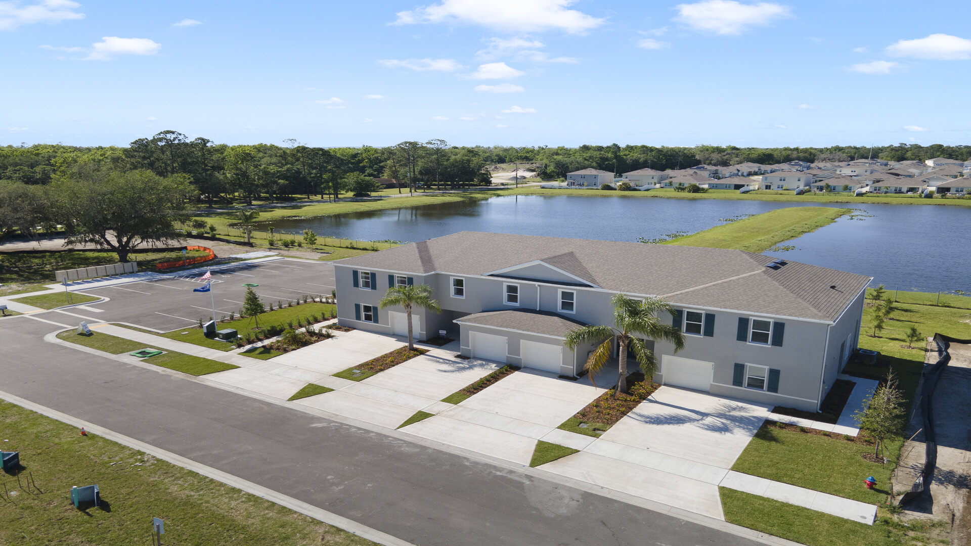 Ariel view of townhomes with lake and greenery behind them