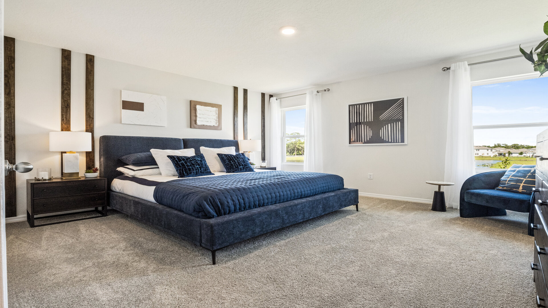 Guest bedroom with bed, nighstands and natural lighting.