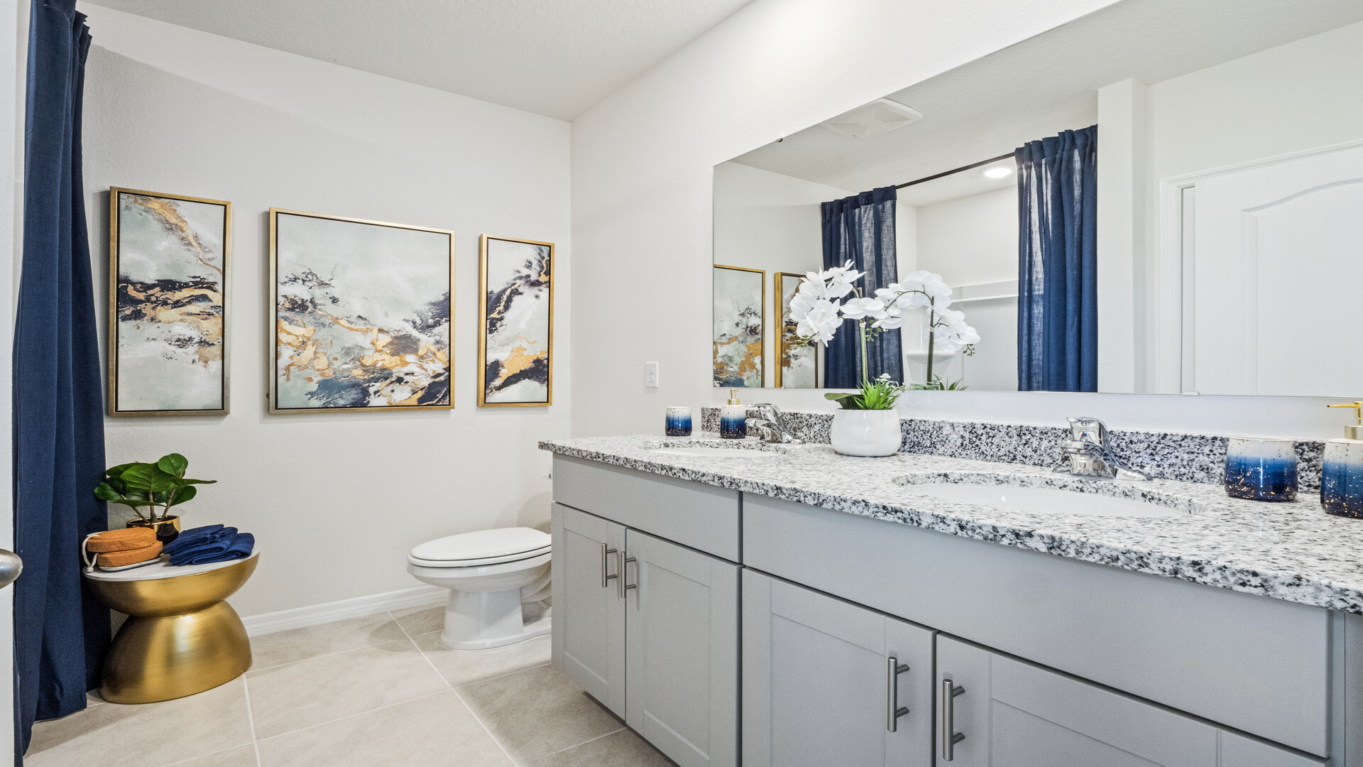 Modern bathroom with single vanity, large wall mirror, cabinets and quartz countertops