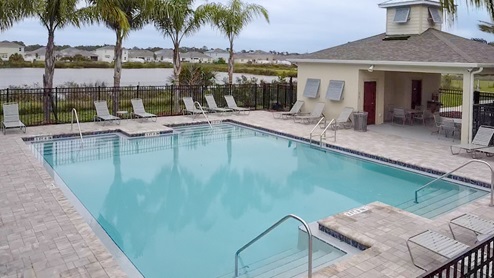 Sunny day at the community swimming pool with lounge seating.