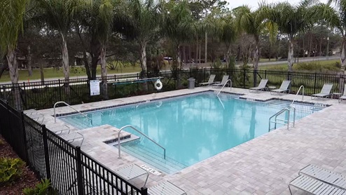 Sunny day at the community swimming pool with lounge seating.