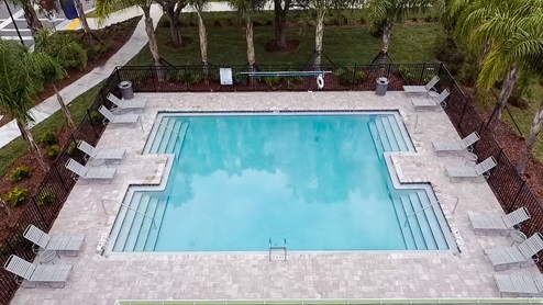 Sunny day at the community swimming pool with lounge seating.