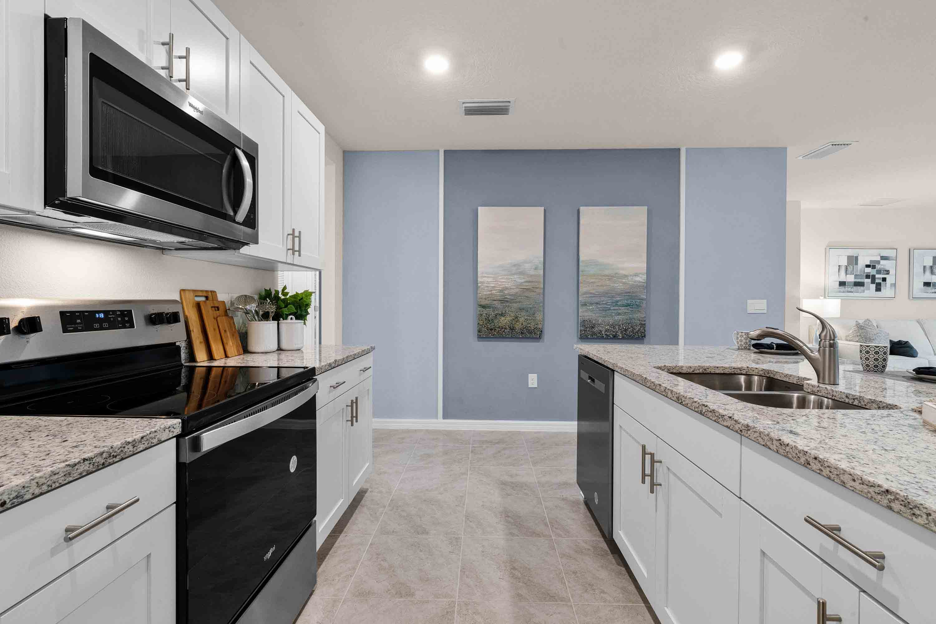 Kitchen with island seating, granite counters, spacious pantry and stainless-steel appliances.