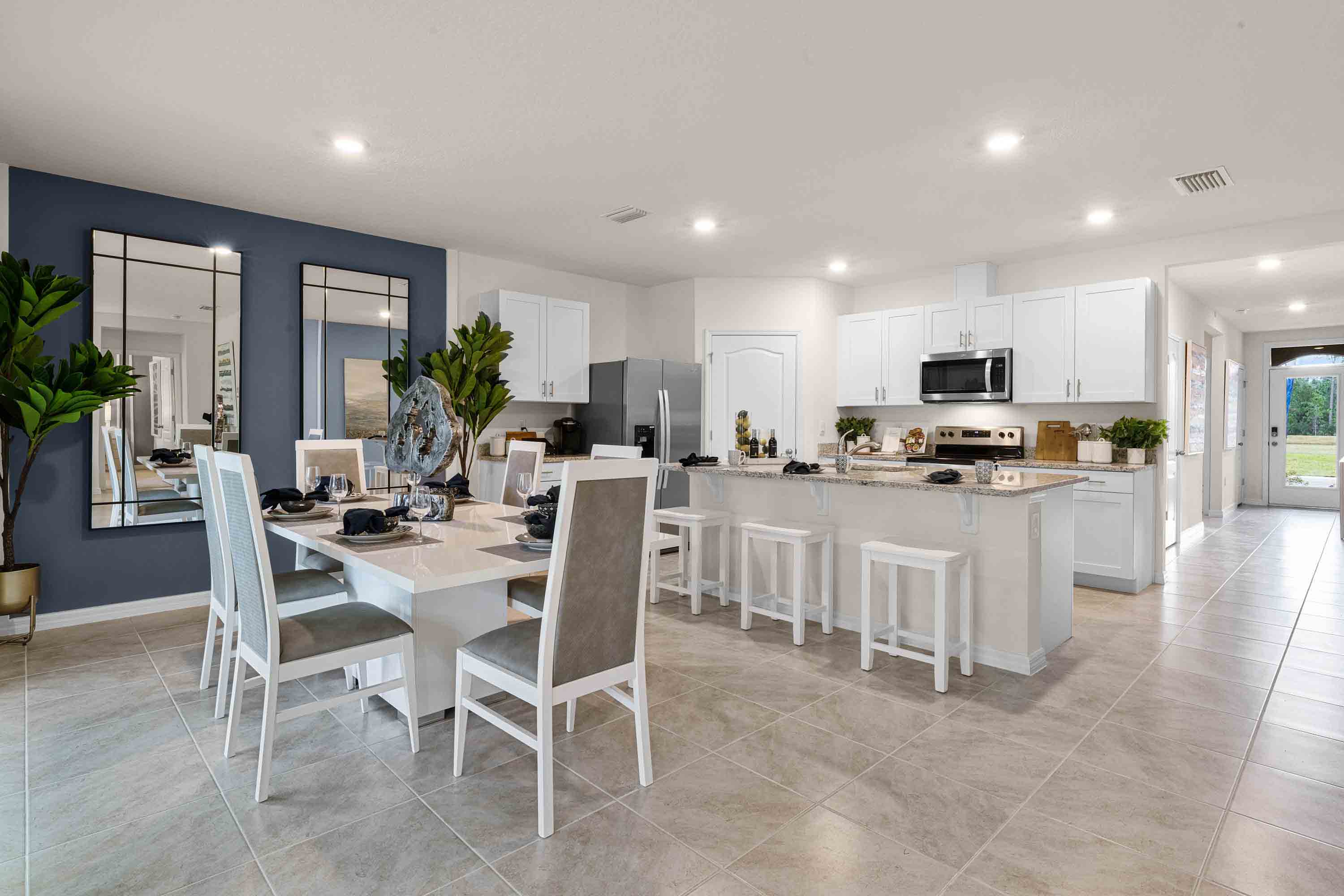 Dining room adjacent to the kitchen with table, chairs and tile flooring.