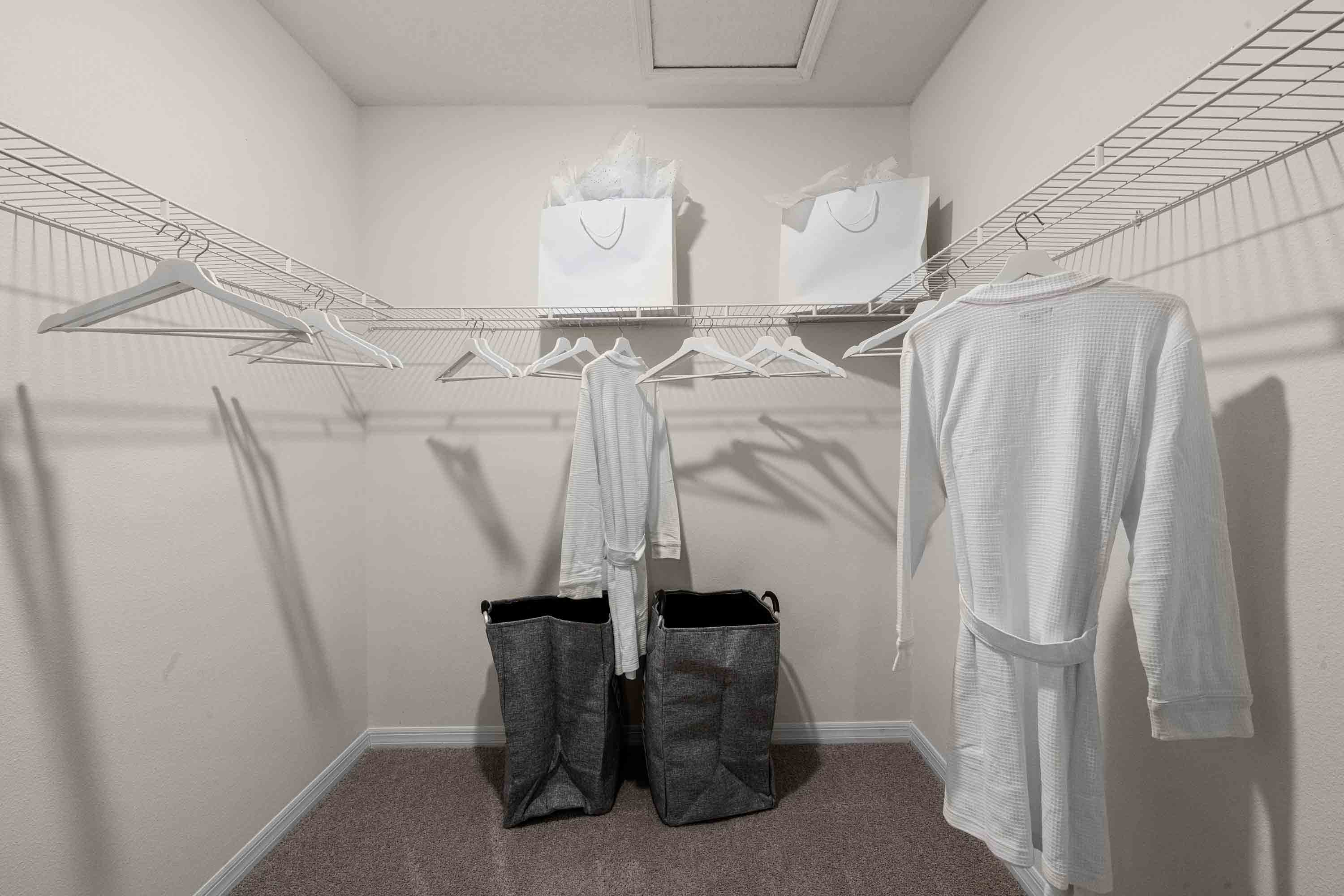 Spacious walk in closet with abundant shelving and storage.