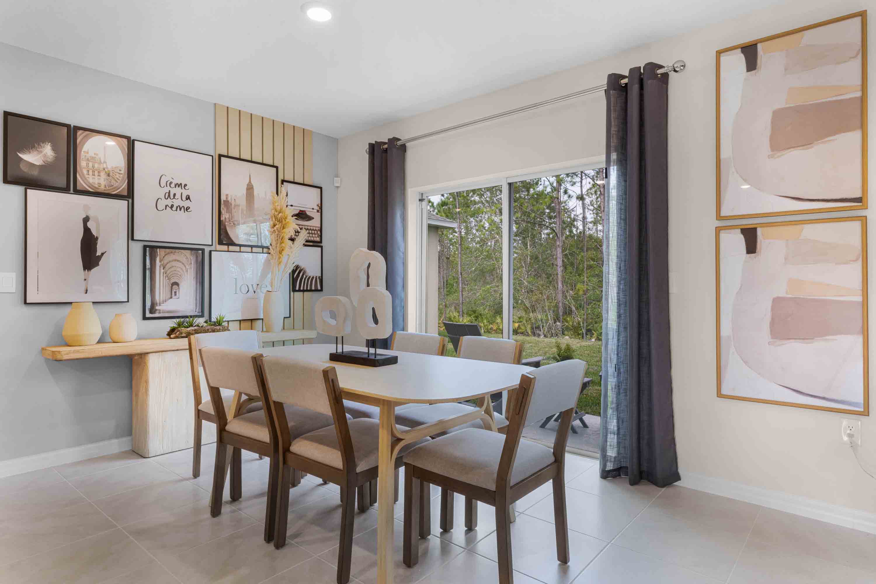 Dining room adjacent to the kitchen with table, chairs and tile flooring.