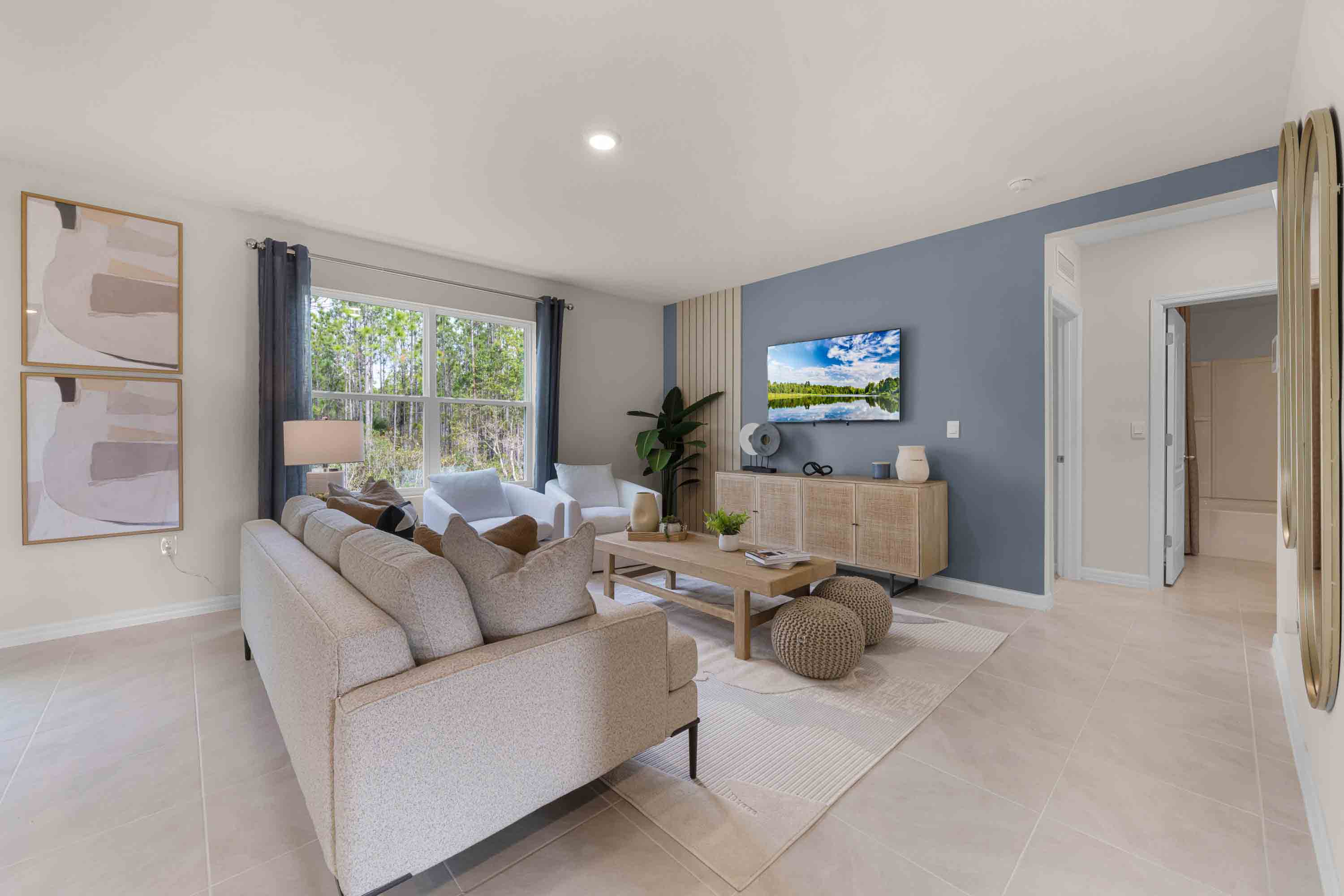 Open concept living area with couch seating and access to the backyard thru slider door.