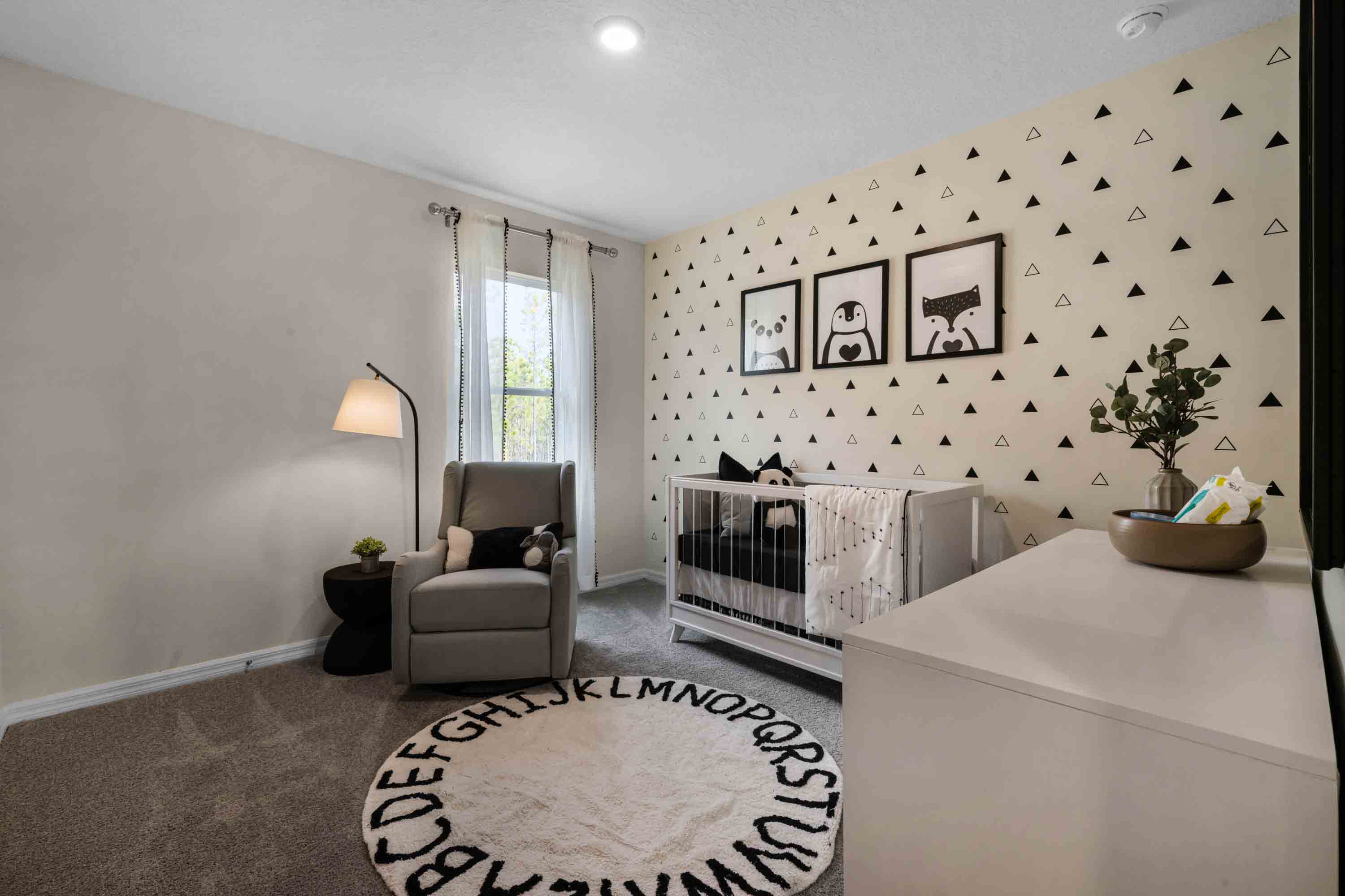 Child's nursery with crib, closet, soft seating and storage.