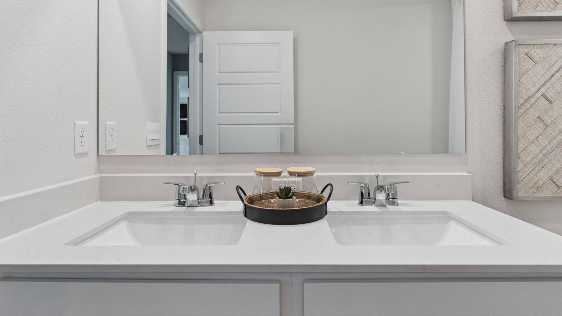 Modern bathroom with double vanity, large wall mirror, cabinets and quartz countertops