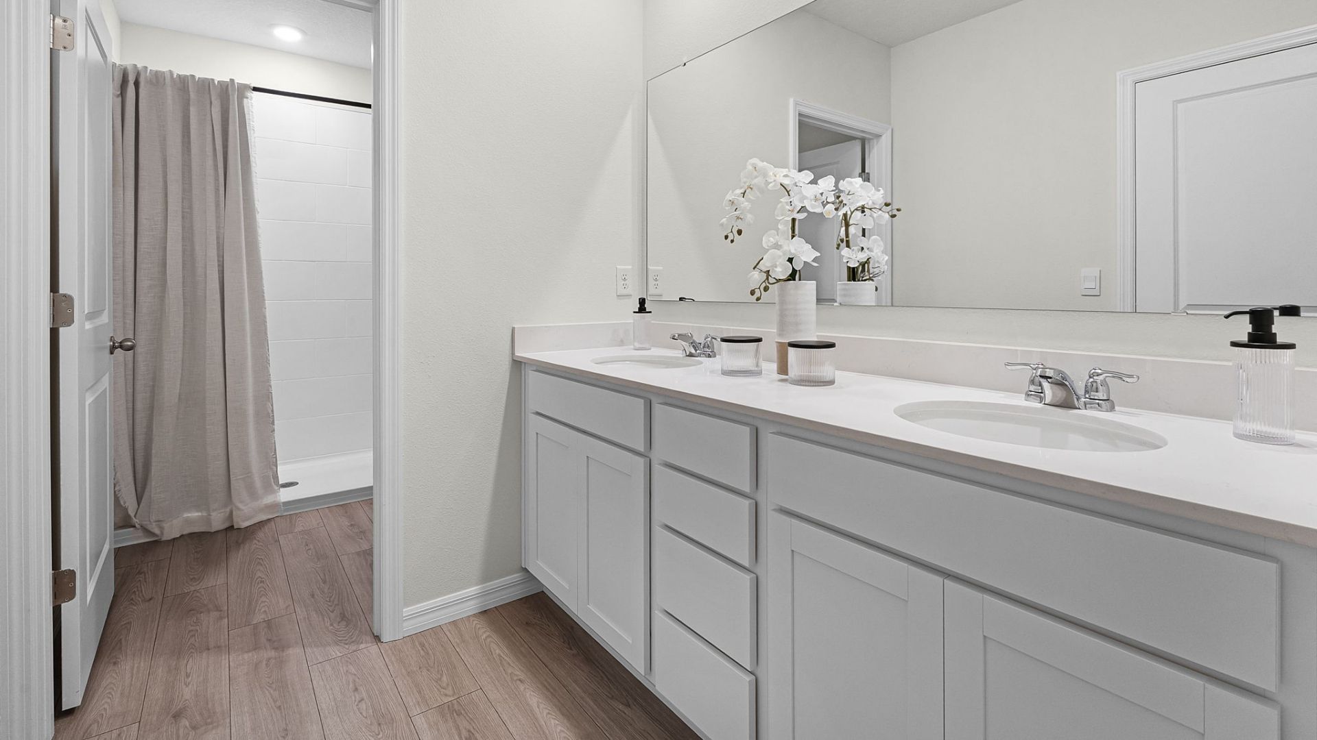 primary bathroom with quartz counters double sink and revwood select flooring