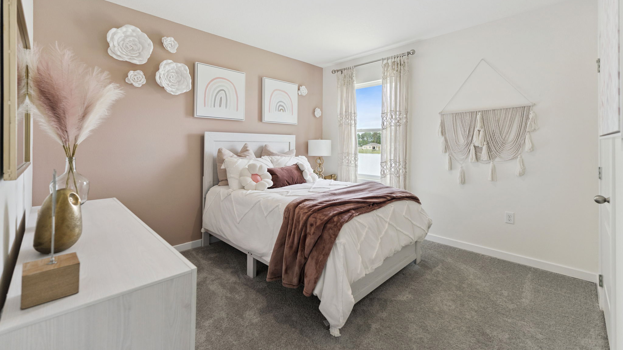 Guest bedroom with bed, nighstand, desk, and natural lighting with spacious closet.