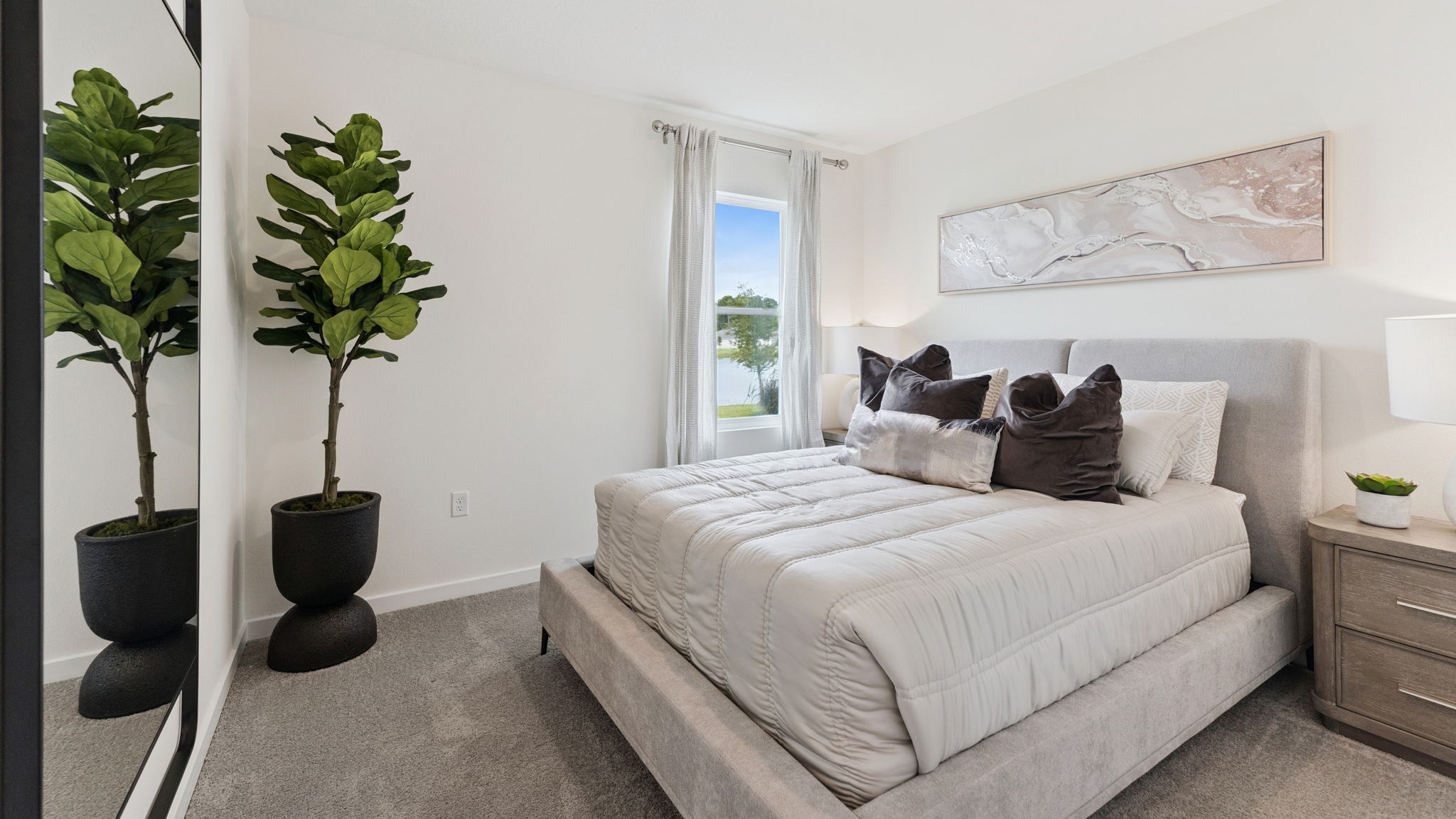 Guest bedroom with bed, nighstand, desk, and natural lighting with spacious closet.
