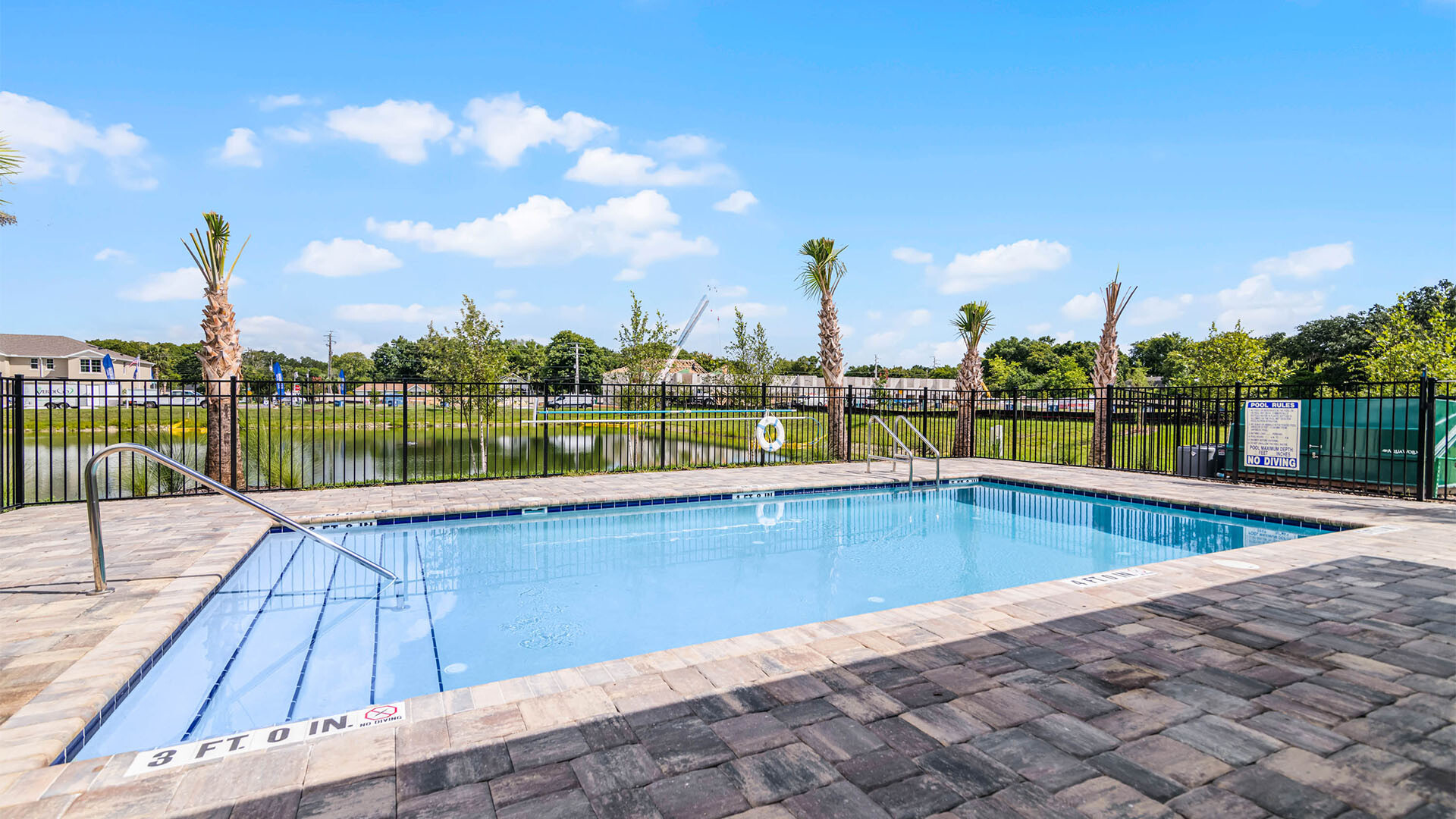 Sunny day at the community swimming pool with lounge seating.