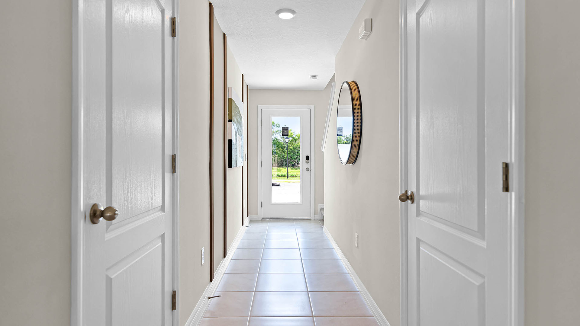 Home entry way thru the front door with tile flooring and a view to the living space.