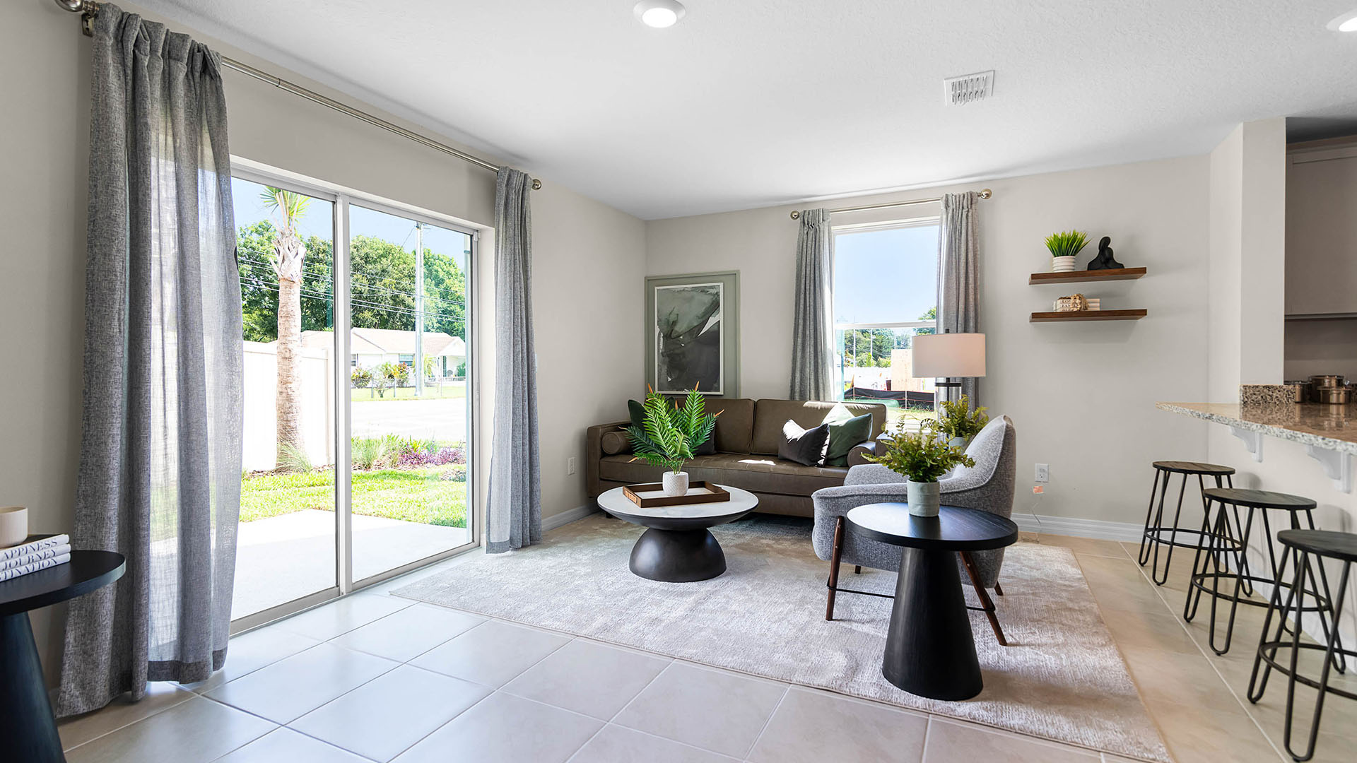 Open concept living area with couch seating and access to the backyard thru slider door.
