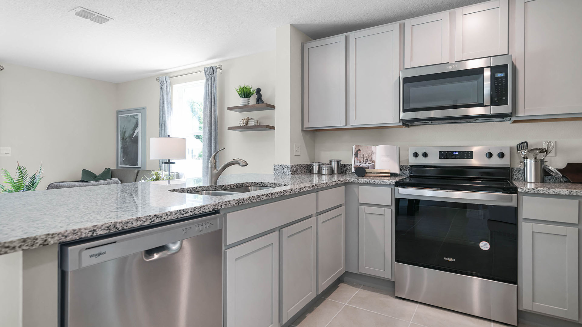 Kitchen with island seating, granite counters, spacious pantry and stainless-steel appliances.